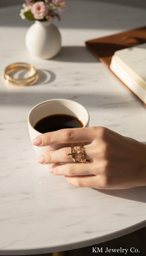 KM Jewelry Co. 18K gold PVD stainless steel ring with a cross and the word "Faith" in script.