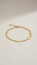 KM Jewelry Co. 18k gold PVD stainless steel cross chain bracelet with delicate faith-inspired detail.