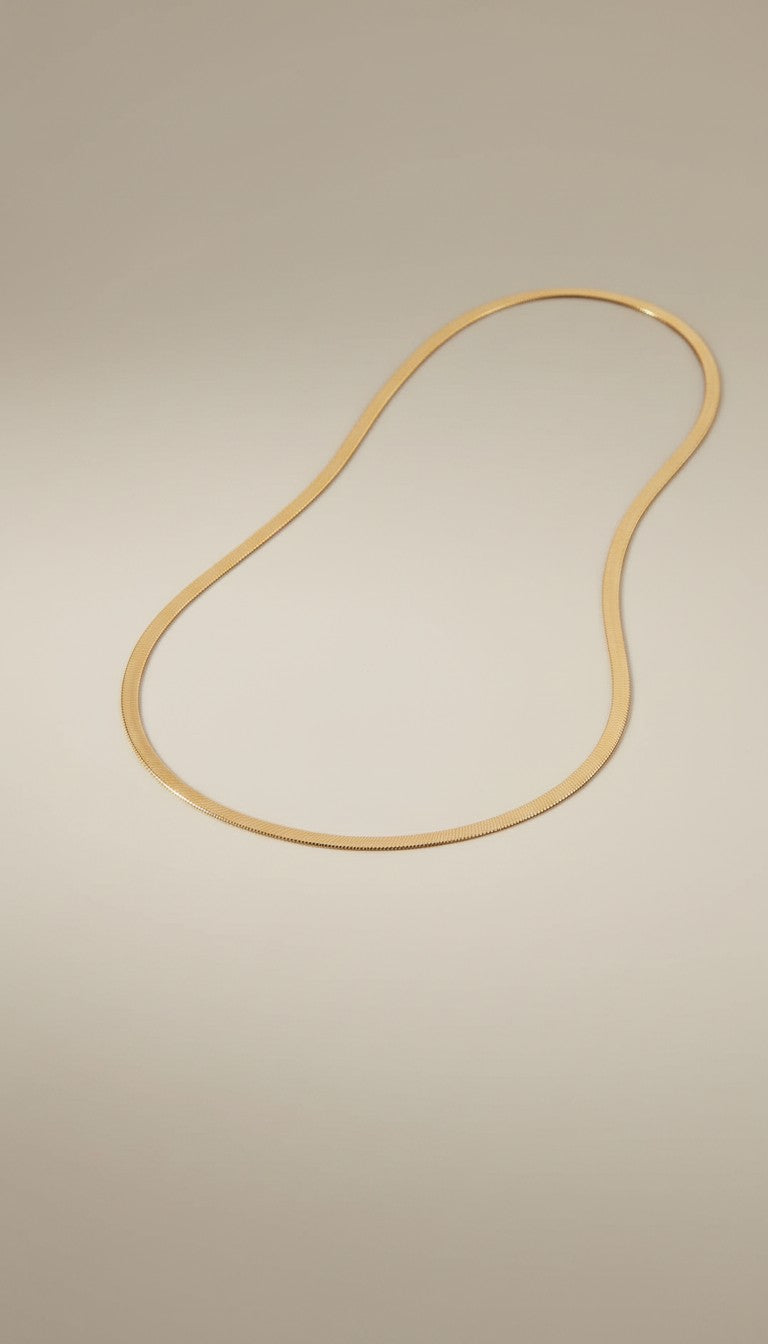 KM Jewelry Co. 18K gold PVD stainless steel herringbone chain necklace on a model.
